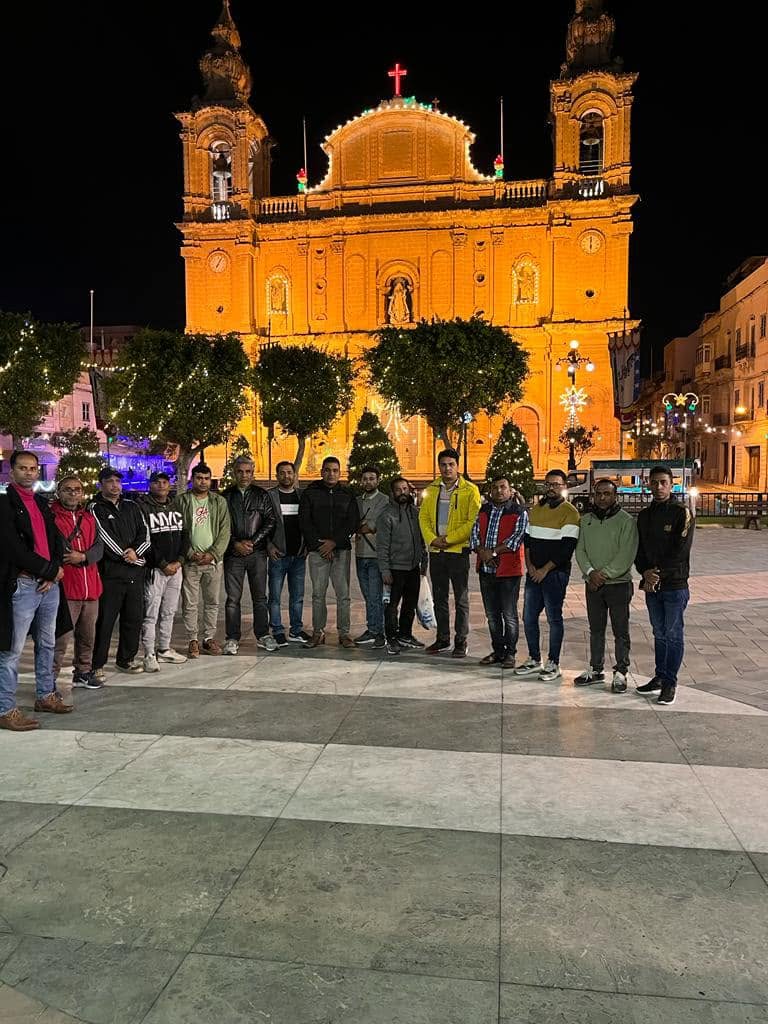 Members gathered in a Maltese town square during a community evening